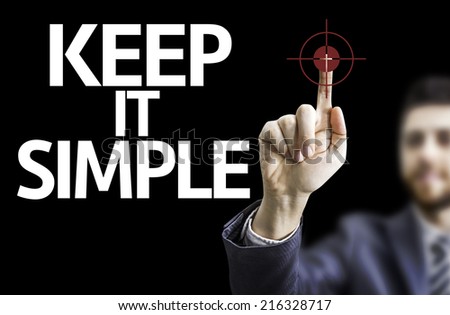 Business man pointing to black board with text: Keep It Simple