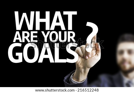 Business man pointing to black board with text: What are Your Goals?