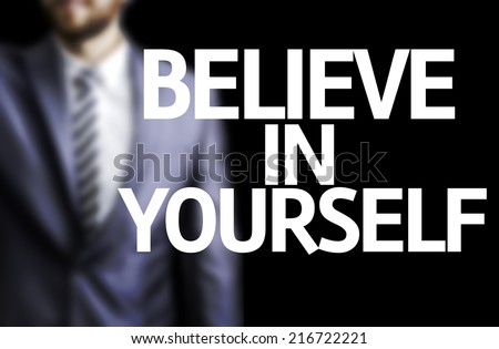Believe in Yourself written on a board with a business man on background