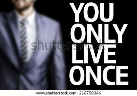 You Only Live Once written on a board with a business man on background