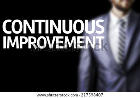 Continuous Improvement written on a board with a business man on background