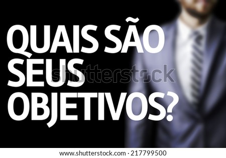 Business man with black board with text: What are Your Goals? (In Portuguese)
