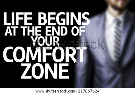 Life Begins at the end of Your Comfort Zone written on a board with a business man on background