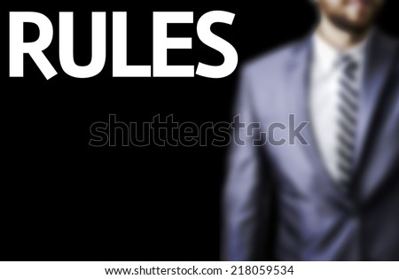 Rules written on a board with a business man on background