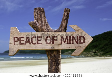 Peace of Mind wooden sign with a beach on background
