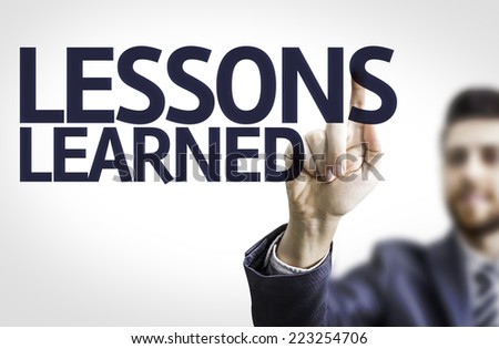 Business man pointing to transparent board with text: Lessons Learned