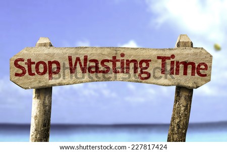 Stop Wasting Time wooden sign with a beach on background