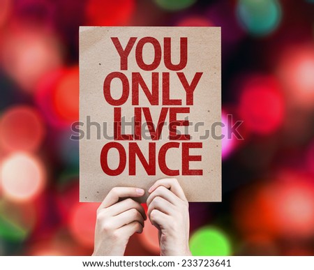 You Only Live Once written on colorful background with defocused lights