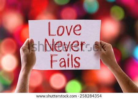 Love Never Fails card with colorful background with defocused lights
