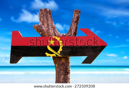 Angola Flag wooden sign with beach background