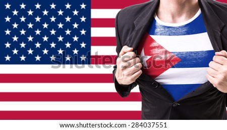 Businessman stretching suit with Cuban Flag on american flag background