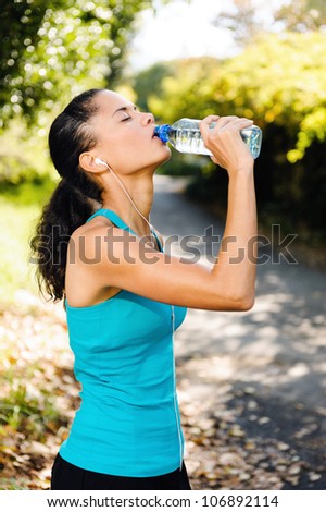 Athlete refreshing with bottle of water after running workout outdoors. marathon runner drinking, healthy active lifestyle.
