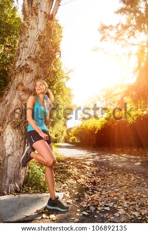 healthy happy fitness woman resting in suburb with water bottle after workout exercise session. vitality lifestyle runner.