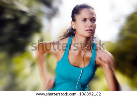 portrait of running healthy fitness woman training for marathon outdoors in alleyway. vitality lifestyle exercise athlete. motion blur speed sprint.