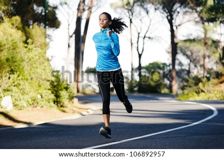 Fitness athlete training alone on a mountain road. Running endurance marathon woman exercising for healthy lifestyle and wellness.