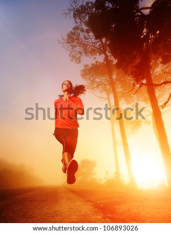 Athlete running on the road in morning sunrise training for marathon and fitness. Healthy active lifestyle latino woman exercising outdoors.