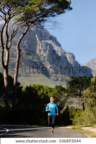 Fitness athlete training alone on a mountain road. Running endurance marathon woman exercising for healthy lifestyle and wellness. panorama with copyspace XXL
