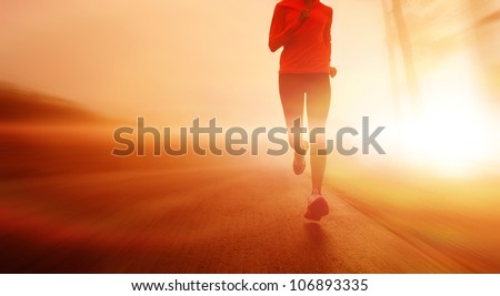 Athlete running on the road in morning sunrise training for marathon and fitness. Healthy active lifestyle, motion blur of woman exercising outdoors. copyspace.