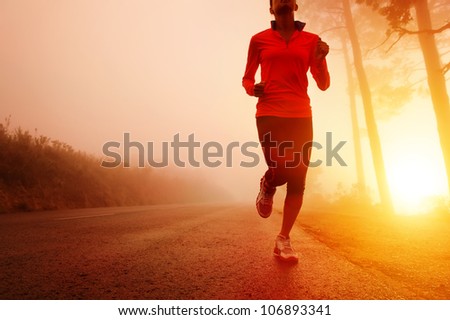 Athlete running on the road in morning sunrise training for marathon and fitness. Healthy active lifestyle latino woman exercising outdoors. Motion blur to show speed.