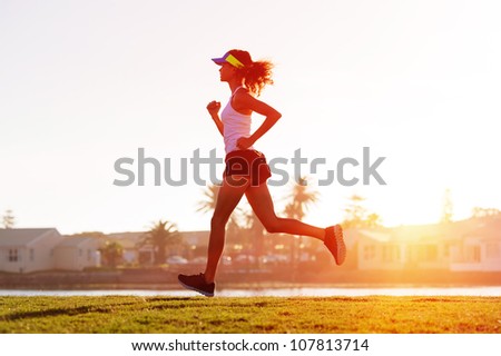silhouette of a woman athlete running at sunset or sunrise. fitness training of marathon runner.