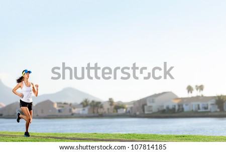 Woman running in suburb park for fitness and wellness exercise. healthy lifestyle active panorama with copyspace