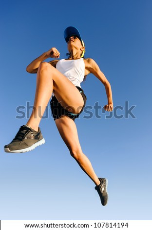 Athlete jumping shot from low angle with sky background