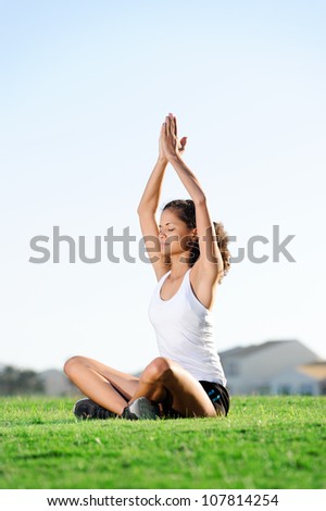 calm zen woman meditating while sitting cross legged on the grass. yoga zen master