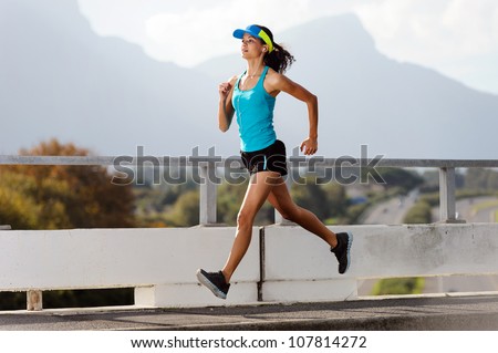 Athlete running on bridge. action shot of runner in mid air. healthy lifestyle fitness woman