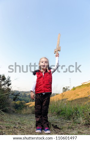 young girl playing pretend explorer adventure game outdoors. cute young child having fun