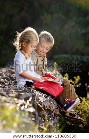 young children playing outdoors, happy brother and sister having fun