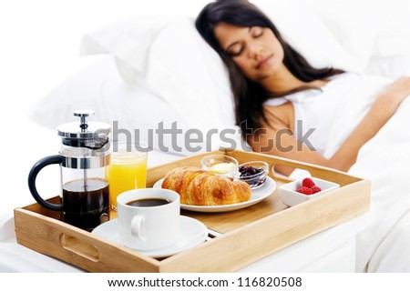 bed and breakfast for attractive young woman sleeping and relaxing with room service isolated on white background