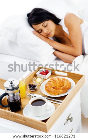 bed and breakfast for attractive young woman sleeping and relaxing with room service isolated on white background