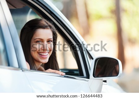 carefree woman in car driving with smile and confidence