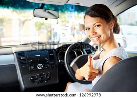Happy woman new car owner smiling and showing keys in driver seat