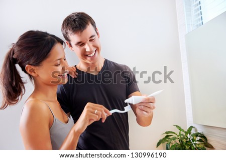 carefree real couple brushing teeth in the bathroom together. daily routine dental health