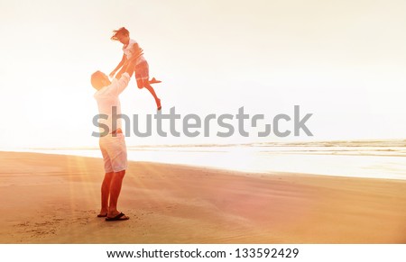 Healthy father and daughter playing together at the beach carefree happy fun smiling lifestyle