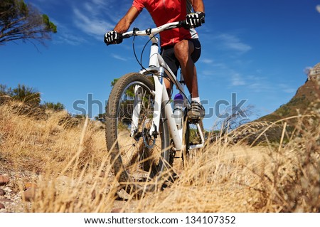 mountain bike man with blue sky riding on outdoor trail in nature
