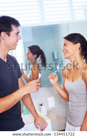 carefree real couple brushing teeth in the bathroom together. daily routine dental health
