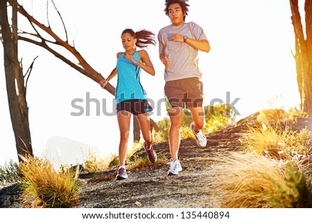 Trail running marathon athlete outdoors sunrise couple training for fitness and healthy lifestyle