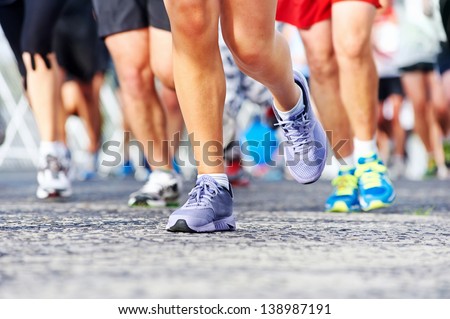 Marathon running race people competing in fitness and healthy active lifestyle feet on road