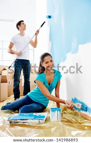 Couple Painting New Home Together With Blue Color Happy And Carefree Relationship