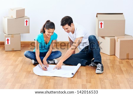 couple moving into new home looking at floor plans together