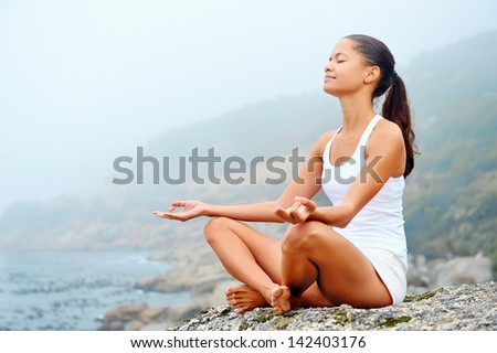 yoga beach woman doing pose at the ocean for zen health and peaceful lifestyle