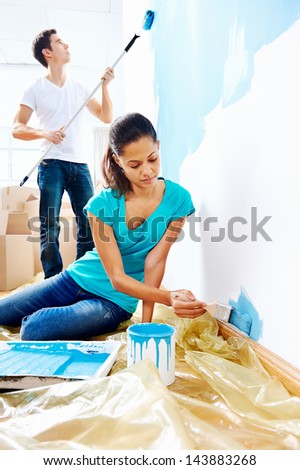 couple painting new home together with blue color happy and carefree relationship