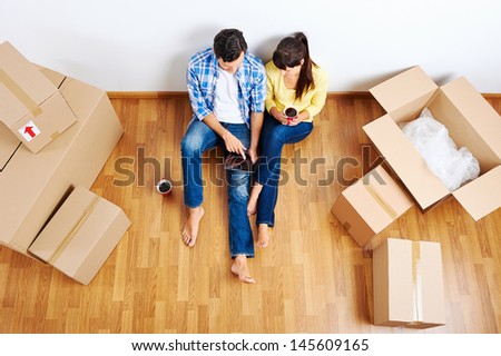 overhead view of couple moving in to new home and using wireless internet on tablet computer