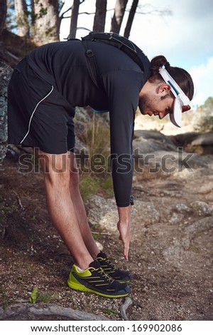 trail runner stretching before running to prevent injury while doing daily fitness routine