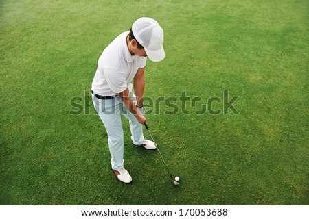 High Overhead Angle View Of Golfer Hitting Golf Ball On Fairway Green Grass