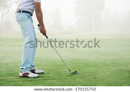 Golfer Hitting Golf Shot With Club On Course While On Summer Vacation
