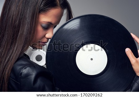 Woman dj portrait with vinyl record and headphones