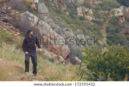 Adventure man hiking wilderness mountain with backpack, outdoor lifestyle survival vacation